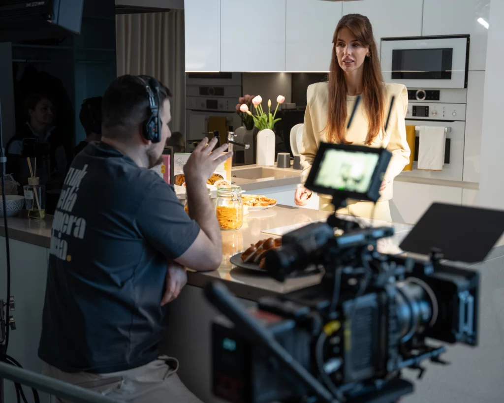 Natáčanie lifestylovej scény do reklamy Gam's v Senci. Režisér komunikuje s herečkou pred rannou joga rutinou v presvetlenom interiéri.